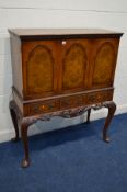 A REPRODUCTION MAHOGANY AND BURR WALNUT TRIPLE DOOR DRINKS CABINET, two internal sections with