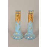 A PAIR OF LIGHT BLUE GLASS BUD VASES, with enamel and gilt detailing, height approximately 19cm (2)