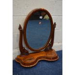 A VICTORIAN WALNUT OVAL TOILET MIRROR, twin foliate supports on a serpentine base, approximate width