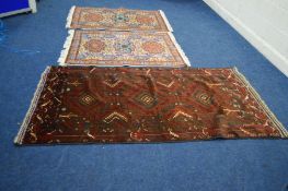 AN EARLY 20TH CENTURY KUBA STYLE RED GROUND RUG, 206cm x 115cm together with a pair of Baluch