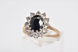 A 9CT GOLD SAPPHIRE CLUSTER RING, the raised cluster designed with a claw set oval cut sapphire