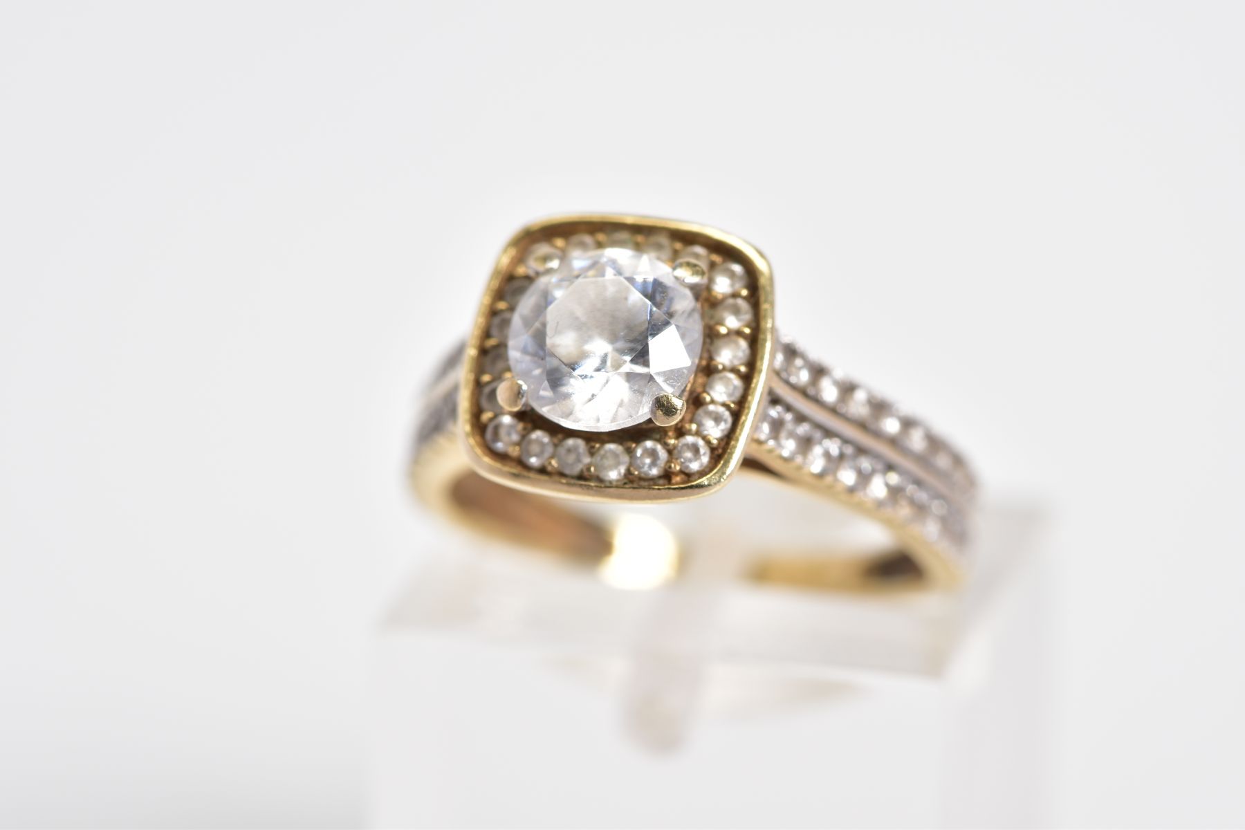 A 9CT GOLD CUBIC ZIRCONIA SET RING, designed with a raised central square panel set with a