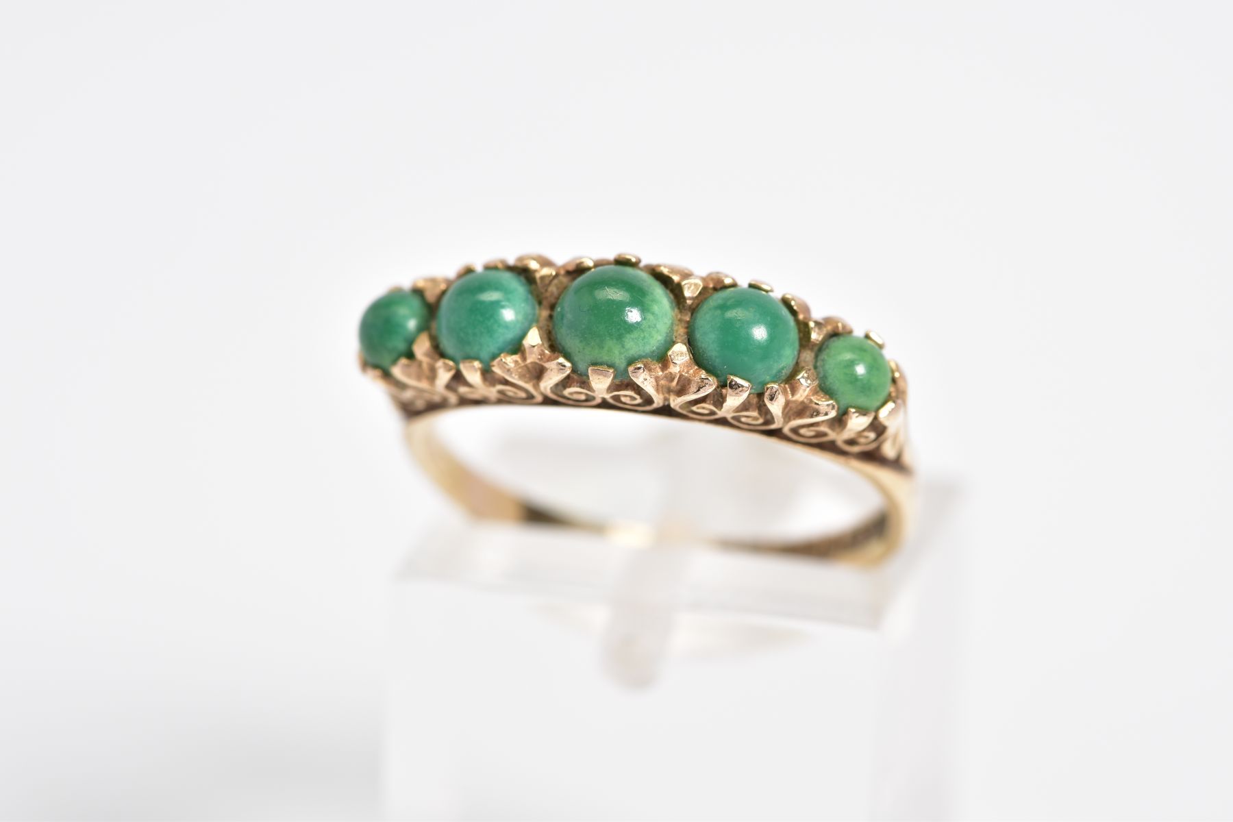 AN EARLY 20TH CENTURY 9CT GOLD RING, set with five graduated circular cut cabochon turquoise, within