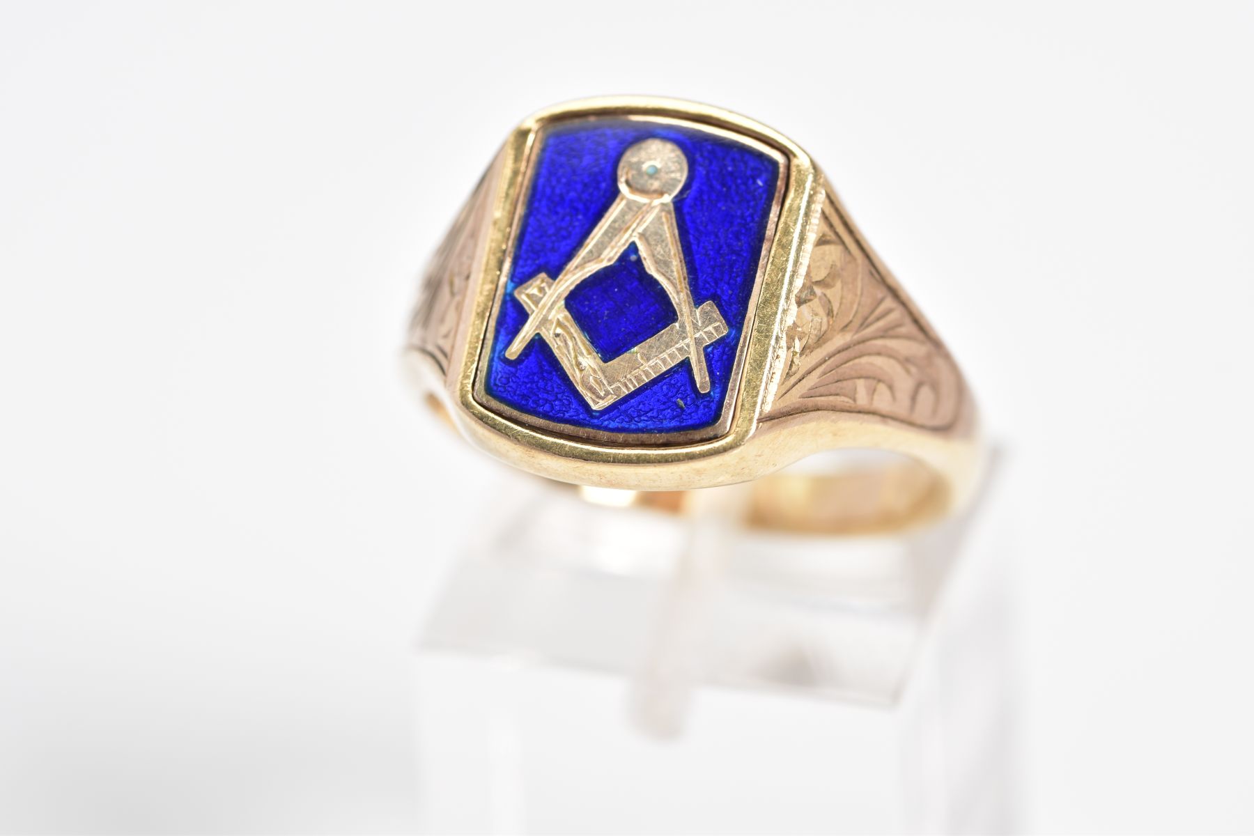A 9CT GOLD MASONIC SIGNET RING, the curved rectangle panel features a blue enamel Masonic emblem,