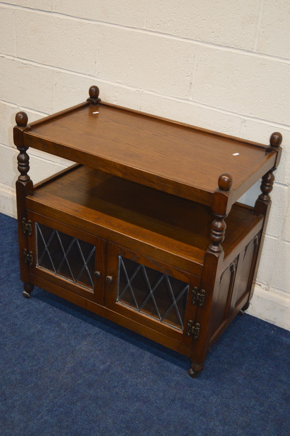 AN OLD CHARM OAK TWO TIER TROLLEY, with double led glazed doors, width 84cm x depth 48cm x height