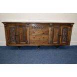 A REPRODUCTION OAK SIDEBOARD, with an overhanging top, two double cupboard doors with foliate
