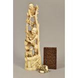 A LATE 19TH CENTURY JAPANESE IVORY OKIMONO, carved as a child standing at the top of some branches