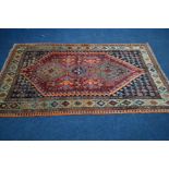 AN EARLY 20TH CENTURY BALUCH RED, BLACK AND ORANGE GROUND RUG, with a multi strap border,