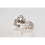 A SINGLE STONE DIAMOND RING, a claw set round brilliant cut diamond within a raised mount, total