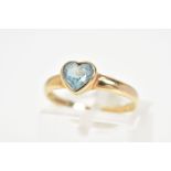 A 9CT GOLD TOPAZ RING, deigned with a central heart shaped topaz in a collet mount, to the plain