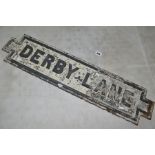 A CAST IRON STREET NAME SIGN, Derby Lane, raised black lettering and edging on white background,