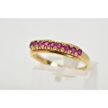 AN 18CT GOLD RUBY RING, of half hoop design set with nine circular cut claw set rubies, to a plain