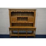 A VICTORIAN PINE DRESSER, the top double panelled doors, open shelves and two drawers above a base