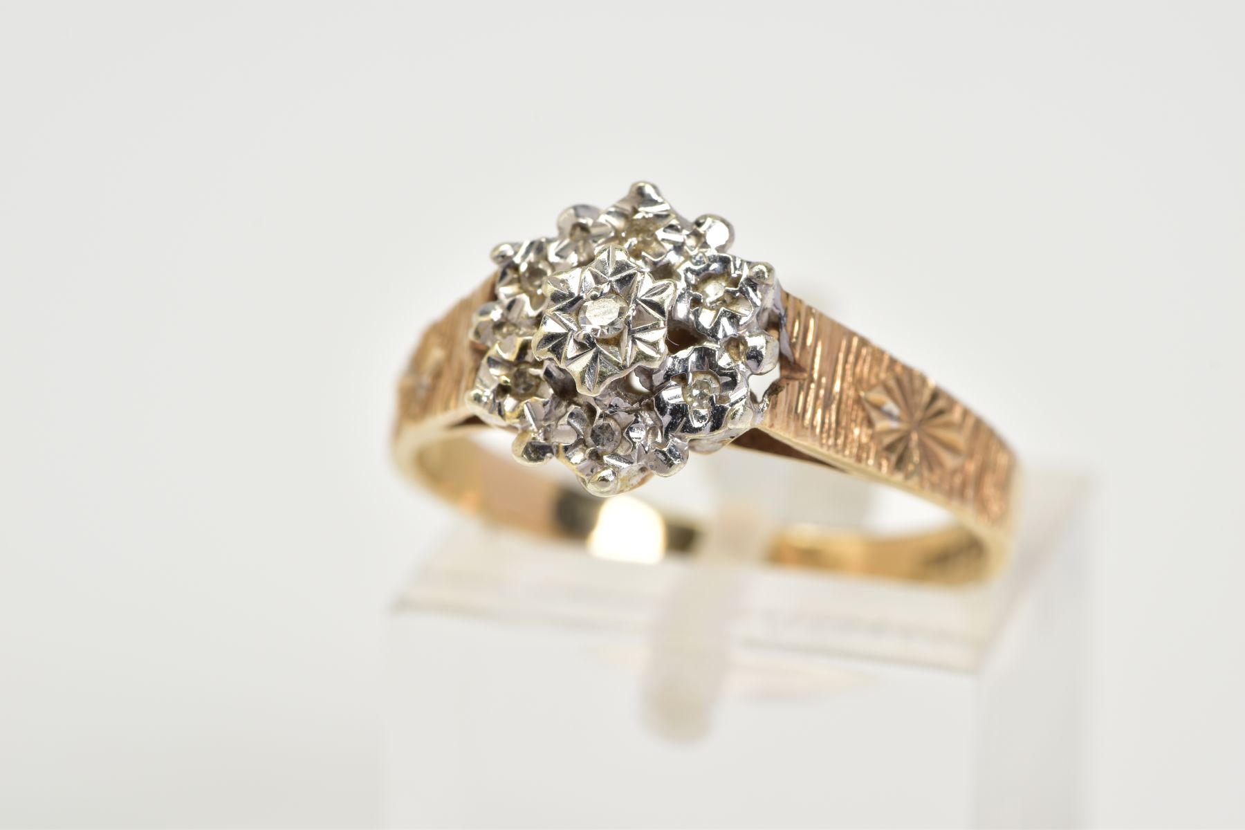 A 9CT GOLD DIAMOND CLUSTER RING, the tiered cluster designed with illusion set single cut diamonds,