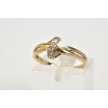 A 9CT GOLD DIAMOND SET RING, of crossover design set with a row of single cut diamonds, to the
