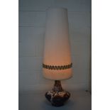 A WEST GERMAN POTTERY TABLE LAMP with a cylindrical tapering fabric shade