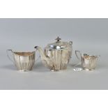 A GEORGE V SILVER BACHELOR'S TEA SET OF FLUTED AND STOP REEDED OVAL FORM, tea pot lacks handle,