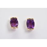 A PAIR OF AMETHYST SET EARRINGS, a pair of yellow metal earrings, each designed with an oval cut