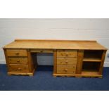 A MODERN PINE DESK with seven assorted drawers, flanked by an open cupboard sections, width 229cm