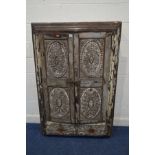 AN ANGLO INDIAN HEAVILY CARVED HARDWOOD RECESSED TWO DOOR CUPBOARD, the doors set in a stepped