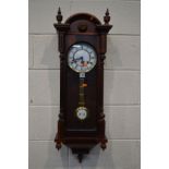 A MODERN MAHOGANY WALL CLOCK with a 31 day movement and roman numerals, height 90cm (winding key and