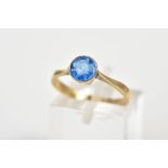 A YELLOW METAL SINGLE STONE RING, set with a circular cut blue stone assessed as paste within a