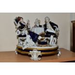 A ROYAL DUX FIGURE GROUP, modelled as an 18th Century couple seated at a tea table, on an oval