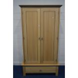 A MODERN OAK TWO DOOR WARDROBE, on a separate base with a single drawer, width 119cm x depth 60cm