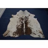 A BROWN AND WHITE COW HIDE, 195cm x 180cm