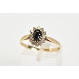 A 9CT GOLD SAPPHIRE CLUSTER RING, the tiered cluster set with a central oval cut sapphire with a