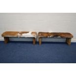 A PAIR OF RUSTIC RECTANGULAR STOOLS with animal hide seat covers, width 152cm x depth 44cm x