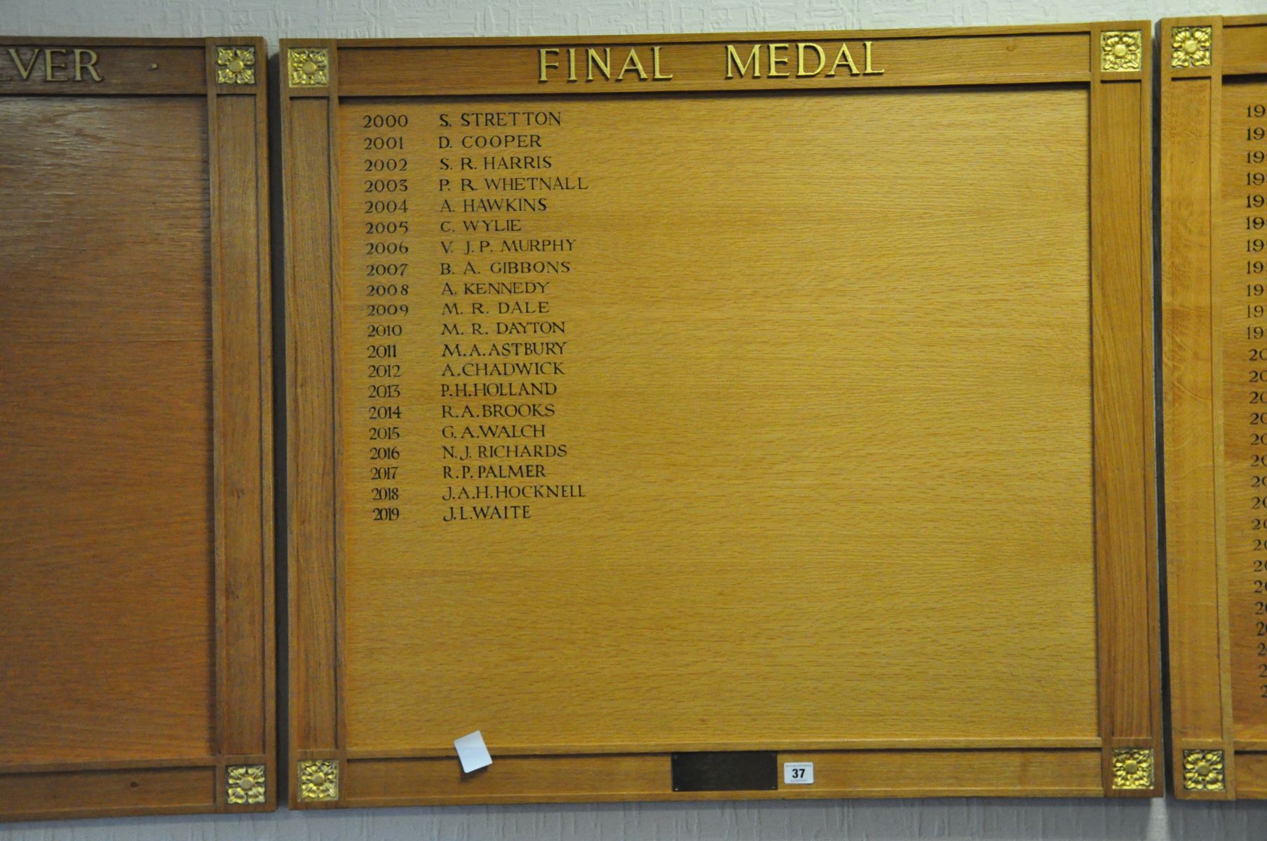 AN OAK FACED HONOURS BOARD, with gilt rose bosses to each corner with a presentation plaque in