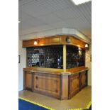 AN OAK RIGHT ANGLED OAK BAR, with hinged entrance, brass hand rails, Safeguard Security Shutter