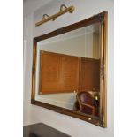 A MODERN ORNATE GILT MIRROR, with bevelled glass, 134cm wide x 104cm high