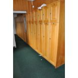 A RUN OF 658CM OAK DOORED LOCKERS, comprising of seventeen units 194cm high 35cm wide with a 134.5cm