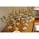 A SET OF TWELVE SLIGHTLY DISTRESSED SILVER PLATED TRIPLE CANDLE STICKS