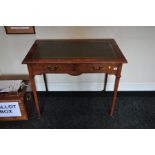 AN EDWARDIAN TWO DRAWER WRITING TABLE, with embossed green leather insert standing on square tapered