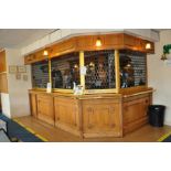 AN OAK RIGHT ANGLED OAK BAR, with hinged entrance, brass hand rails, Safeguard Security Shutter