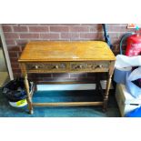 A MODERN CARVED OAK TWO DRAWER SIDE TABLE, (possibly Wood Brothers), with turned legs and