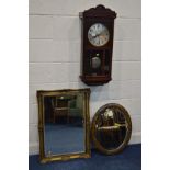 AN EARLY 20TH CENTURY OAK WALL CLOCK (winding key and pendulum) and a gilt framed bevelled edge wall