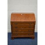 A REPRODUCTION YEWWOOD BUREAU with a fitted interior with a tambour centre, four exterior drawers,