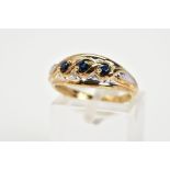 A 9CT GOLD SAPPHIRE RING, designed with three graduated circular cut sapphires, within a cross