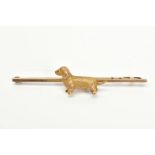 A 9CT GOLD BAR BROOCH, set with a textured dog, to the plain polished bar with a 9ct hallmark,
