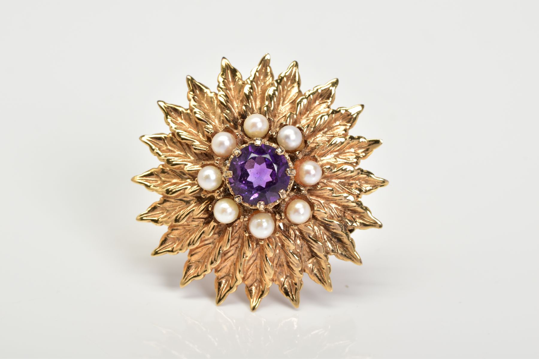 A 9CT GOLD AMETHYST AND PEARL BROOCH, of floral design set with a central circular cut amethyst