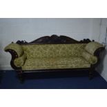 A REGENCY MAHOGANY FOLIATE SCROLLED SOFA, with roundels to the back, on turned legs with brass