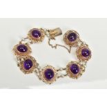 A 9CT GOLD AMETHYST AND PEARL BRACELET, seven panels each set with an oval cut cabochon amethyst
