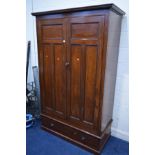 AN EDWARDIAN MAHOGANY PANELLED DOUBLE DOOR WARDROBE, with a door handle/locking key, above a