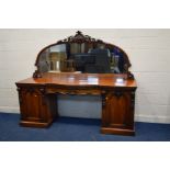 A LATE VICTORIAN MAHOGANY PEDESTAL MIRRORBACK SIDEBOARD, with heavily carved foliate and scrolled