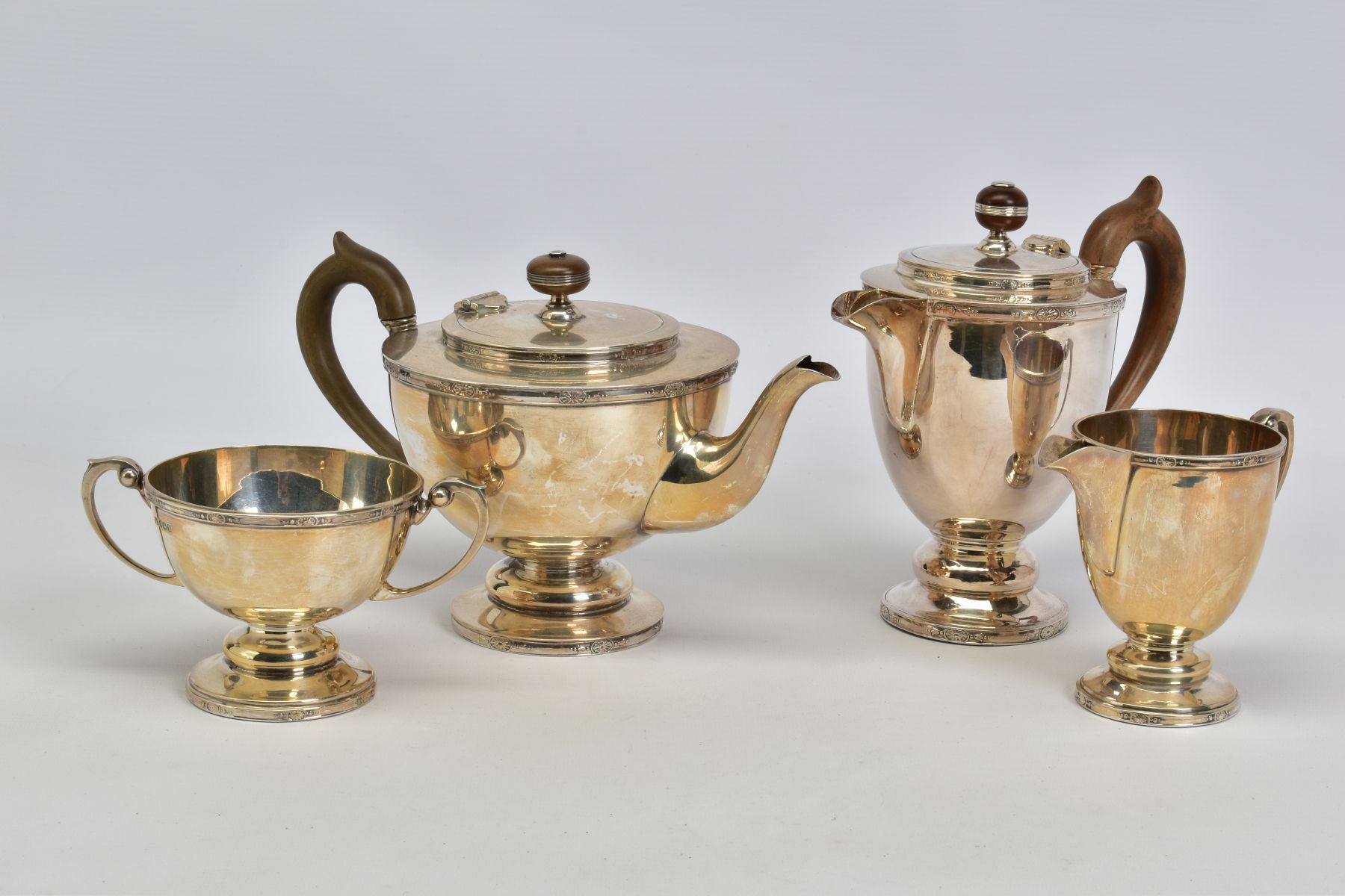 A MATCHED GEORGE V AND ELIZABETH II SILVER FOUR PIECE TEA SERVICE OF CIRCULAR FORM, cast rims with