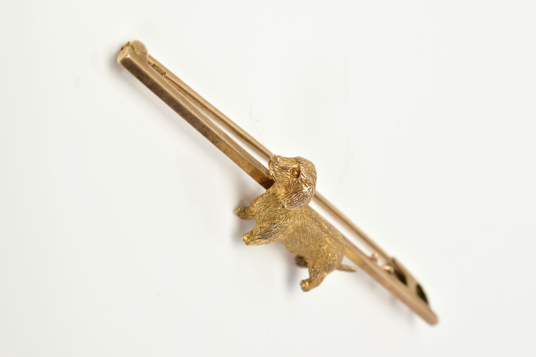 A 9CT GOLD BAR BROOCH, set with a textured dog, to the plain polished bar with a 9ct hallmark, - Image 2 of 3